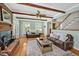 Comfortable living room featuring hardwood floors, exposed wood beams, fireplace, and cozy furniture at 4702 Pleasant Green Rd, Durham, NC 27705