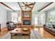 Spacious living room with a brick fireplace, wood floors, and ample natural light at 4702 Pleasant Green Rd, Durham, NC 27705