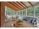 Inviting sunroom with exposed beams, screened windows, and comfortable seating for relaxing and entertaining at 4702 Pleasant Green Rd, Durham, NC 27705
