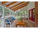 Bright sunroom featuring a wooden bench with decorative pillows and rustic coffee table at 4702 Pleasant Green Rd, Durham, NC 27705