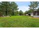 Large backyard with a fire pit, sheds, a wooded fence line, and mature trees at 50 Rainwood Ct, Louisburg, NC 27549