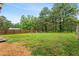 Expansive backyard with a lush green lawn, mature trees, and a wooded fence line at 50 Rainwood Ct, Louisburg, NC 27549