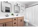 Bright bathroom features a double vanity, modern fixtures, and a shower with a white curtain at 50 Rainwood Ct, Louisburg, NC 27549