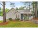 Inviting single-story home with a quaint front porch and a well-maintained lawn surrounded by mature trees at 50 Rainwood Ct, Louisburg, NC 27549
