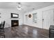 Bright living room with a charming fireplace, hardwood floors, and two large windows at 50 Rainwood Ct, Louisburg, NC 27549