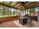 Screened in patio with wood supports, gravel, a ceiling fan, and outdoor seating with a table at 50 Rainwood Ct, Louisburg, NC 27549