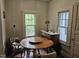 Cozy dining area with hardwood floors, vintage table set, sideboard and natural light from multiple windows at 500 W Main St, Benson, NC 27504