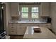 Charming kitchen with white cabinetry and a view of the lawn through double windows above the sink at 500 W Main St, Benson, NC 27504