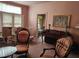 Living room featuring a piano and antique chairs with floral carpeting and large windows at 500 W Main St, Benson, NC 27504
