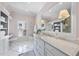 Bright bathroom with a marble countertop vanity, white cabinets, and checkered tile flooring at 504 Yarmouth Rd, Raleigh, NC 27608