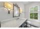 Stylish bathroom with marble countertop, a decorative mirror, and a window offering natural light at 504 Yarmouth Rd, Raleigh, NC 27608
