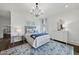 Bright bedroom with blue accents, featuring a chandelier and decorative area rug on hardwood floors at 504 Yarmouth Rd, Raleigh, NC 27608