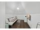 Cozy bonus room featuring a white sofa, hardwood floors, and a wall-mounted television at 504 Yarmouth Rd, Raleigh, NC 27608