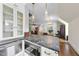 Elegant kitchen with marble counters, white cabinets, stainless steel appliances and adjacent living spaces at 504 Yarmouth Rd, Raleigh, NC 27608