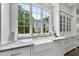 Bright kitchen features a farmhouse sink, brass faucet, and marble countertops under a large window with green views at 504 Yarmouth Rd, Raleigh, NC 27608