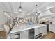 Large kitchen island with marble countertop and bar seating with decorative pendant lighting, open to living spaces at 504 Yarmouth Rd, Raleigh, NC 27608