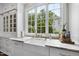 Well-lit kitchen with marble counters, farmhouse sink, brass fixtures, and a large window at 504 Yarmouth Rd, Raleigh, NC 27608