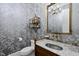 Charming powder room with decorative wallpaper, marble counter and elegant fixtures at 504 Yarmouth Rd, Raleigh, NC 27608