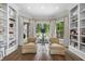 Bright sitting area featuring built-in bookshelves, hardwood floors, and large windows offering lush backyard views at 504 Yarmouth Rd, Raleigh, NC 27608