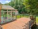 Backyard featuring a wood deck, fenced-in area, sunroom, and outdoor fireplace at 5108 Briton Pl, Fuquay Varina, NC 27526