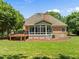 Expansive backyard showcasing a wood deck, a sunroom, and lush green lawn at 5108 Briton Pl, Fuquay Varina, NC 27526