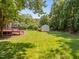 Expansive backyard with lush green grass, a storage shed and mature shade trees at 5108 Briton Pl, Fuquay Varina, NC 27526