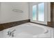 Relaxing bathroom showing soaking tub with tile trim, large window and chrome hardware at 5108 Briton Pl, Fuquay Varina, NC 27526
