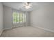 Bright, carpeted bedroom featuring a ceiling fan, shuttered window, and neutral color scheme at 5108 Briton Pl, Fuquay Varina, NC 27526