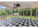 Spacious sunroom with checkered flooring, surrounded by lush greenery through expansive windows at 5108 Briton Pl, Fuquay Varina, NC 27526