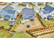 Aerial view of backyard with patio, fire pit, trampoline, screened porch, and landscaped garden at 512 Teal Lake Dr, Holly Springs, NC 27540