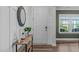 Bright foyer featuring wood-look floors, modern trim, a stylish console table, mirror and a white front door at 512 Teal Lake Dr, Holly Springs, NC 27540