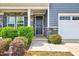 Welcoming front entrance with stone accents, neat landscaping, and a stylish black front door at 512 Teal Lake Dr, Holly Springs, NC 27540