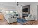 Inviting living room featuring a modern fireplace, large windows, hardwood floors, and comfortable seating at 512 Teal Lake Dr, Holly Springs, NC 27540