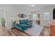 Spacious living room with a comfortable teal sectional sofa, neutral walls, and a dedicated desk/work area at 512 Teal Lake Dr, Holly Springs, NC 27540