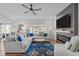 Comfortable living room featuring a large sectional sofa, a fireplace, hardwood floors, and plenty of natural light at 512 Teal Lake Dr, Holly Springs, NC 27540