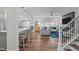 Open-concept living space with a kitchen island, living room seating, and a view of the staircase at 512 Teal Lake Dr, Holly Springs, NC 27540