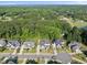 Areal shot of suburban neighborhood showcasing well-manicured lawns, mature trees, and nearby pond at 517 Myrna Ln, Wake Forest, NC 27587