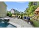 Backyard retreat featuring a pool with cascading waterfall, comfortable seating areas, and a playset, perfect for outdoor relaxation at 517 Myrna Ln, Wake Forest, NC 27587
