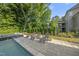 A backyard oasis with modern lounge chairs and a pristine pool amidst lush greenery at 517 Myrna Ln, Wake Forest, NC 27587