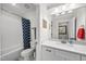 Well-lit bathroom with a vanity, mirror, and combined tub and shower with a patterned shower curtain at 517 Myrna Ln, Wake Forest, NC 27587