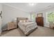 Bright bedroom showcases an upholstered bed, a dresser, and two large windows at 517 Myrna Ln, Wake Forest, NC 27587
