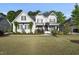 Stunning two-story home with manicured lawn and charming architectural details on a sunny day at 517 Myrna Ln, Wake Forest, NC 27587