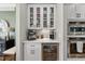 Elegant white kitchen beverage center with beverage fridge, wine storage, and stainless KitchenAid double ovens at 517 Myrna Ln, Wake Forest, NC 27587