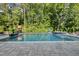Inviting backyard pool surrounded by lush greenery and a stone patio at 517 Myrna Ln, Wake Forest, NC 27587