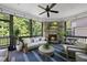 Cozy screened porch featuring a stone fireplace, comfortable seating, and views of the surrounding greenery at 517 Myrna Ln, Wake Forest, NC 27587