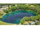 Breathtaking aerial view of a neighborhood and a beautiful lake surrounded by lush, mature trees at 5216 Sunset Fairways Dr, Holly Springs, NC 27540