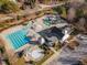 Aerial view of water park including pools, slides, umbrellas, lounge chairs and parking at 5216 Sunset Fairways Dr, Holly Springs, NC 27540