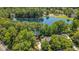 Breathtaking aerial view of a luxury home nestled by a picturesque lake, surrounded by mature trees at 5216 Sunset Fairways Dr, Holly Springs, NC 27540