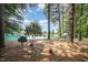 A tranquil lakeside setting with lush trees, a sandy beach, and inviting seating, ideal for peaceful relaxation at 5216 Sunset Fairways Dr, Holly Springs, NC 27540