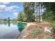 Picturesque lakeside backyard with seating, offering a tranquil retreat with stunning water views at 5216 Sunset Fairways Dr, Holly Springs, NC 27540